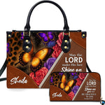 Front view of leopard print and amber butterfly handbag and matching wallet with blooming roses and diagonal trim.
