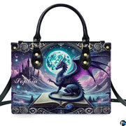 Structured fantasy dragon handbag displayed with shoulder strap on plain white background.
