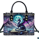 Structured fantasy dragon handbag displayed with shoulder strap on plain white background.