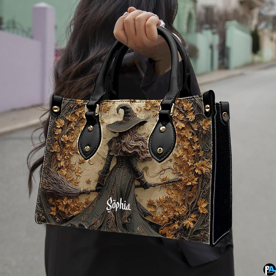 Gothic autumn witch handbag held by top handle while walking outdoors along a street.