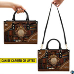 Bookshelf handbag carrying demonstration showing top handle and shoulder strap carry.