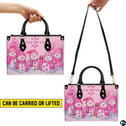 Demonstration of handbag carried by black top handles and worn across the shoulder using long strap.