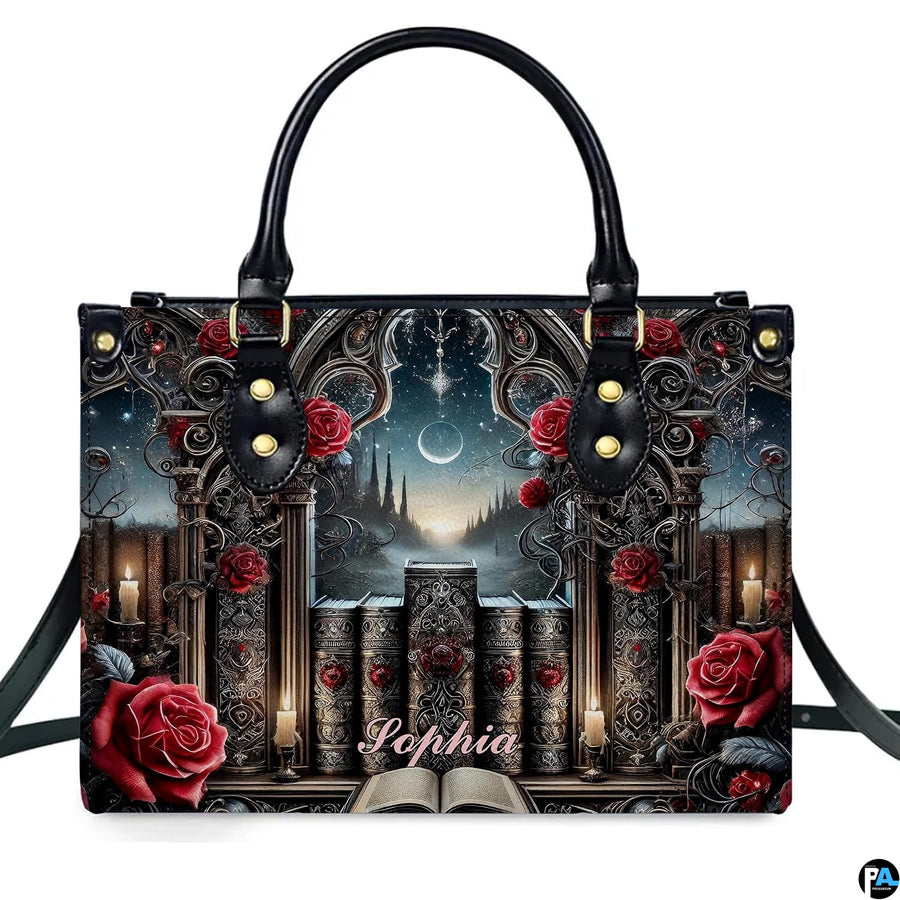 Isolated front view of gothic cathedral handbag showing stone window arch, grimoires, and crimson roses.