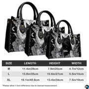 Gothic black cat handbag displayed on white table beside floral bouquet.