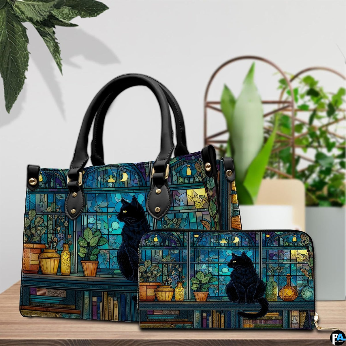Tabletop scene presenting midnight stained glass cat artwork resting on wood beside green houseplants.