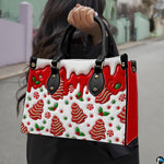 Outdoor lifestyle view of model holding gingerbread tree handbag displaying candy pattern and red side panel.