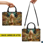 Close-up front view of handbag showing shepherd, lamb, and impressionist wildflowers