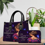 Woman portrait handbag and matching wallet displayed on a wooden surface beside decorative greenery.