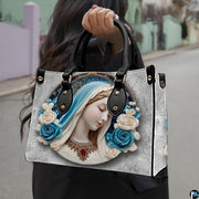 Lifestyle model carrying the Virgin Mary cerulean cameo devotional handbag outdoors