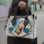 Lifestyle model carrying the Virgin Mary cerulean cameo devotional handbag outdoors
