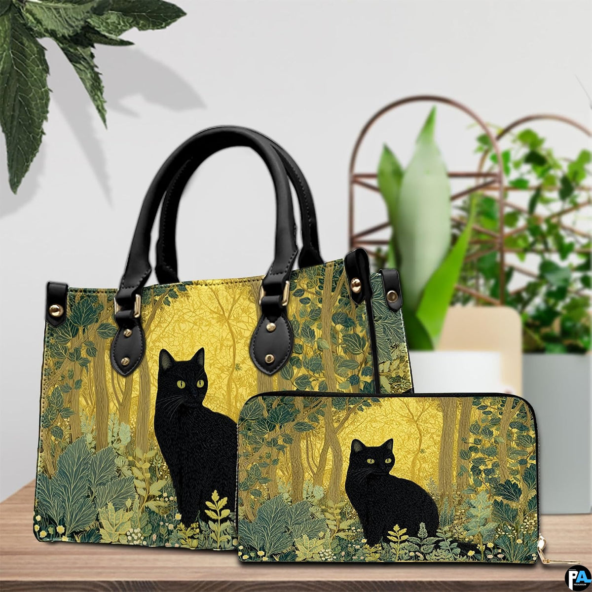 Tabletop arrangement showing vintage black cat woodland print beside potted houseplants.