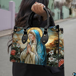 Model wearing stained glass Virgin Mary handbag over shoulder with strap.