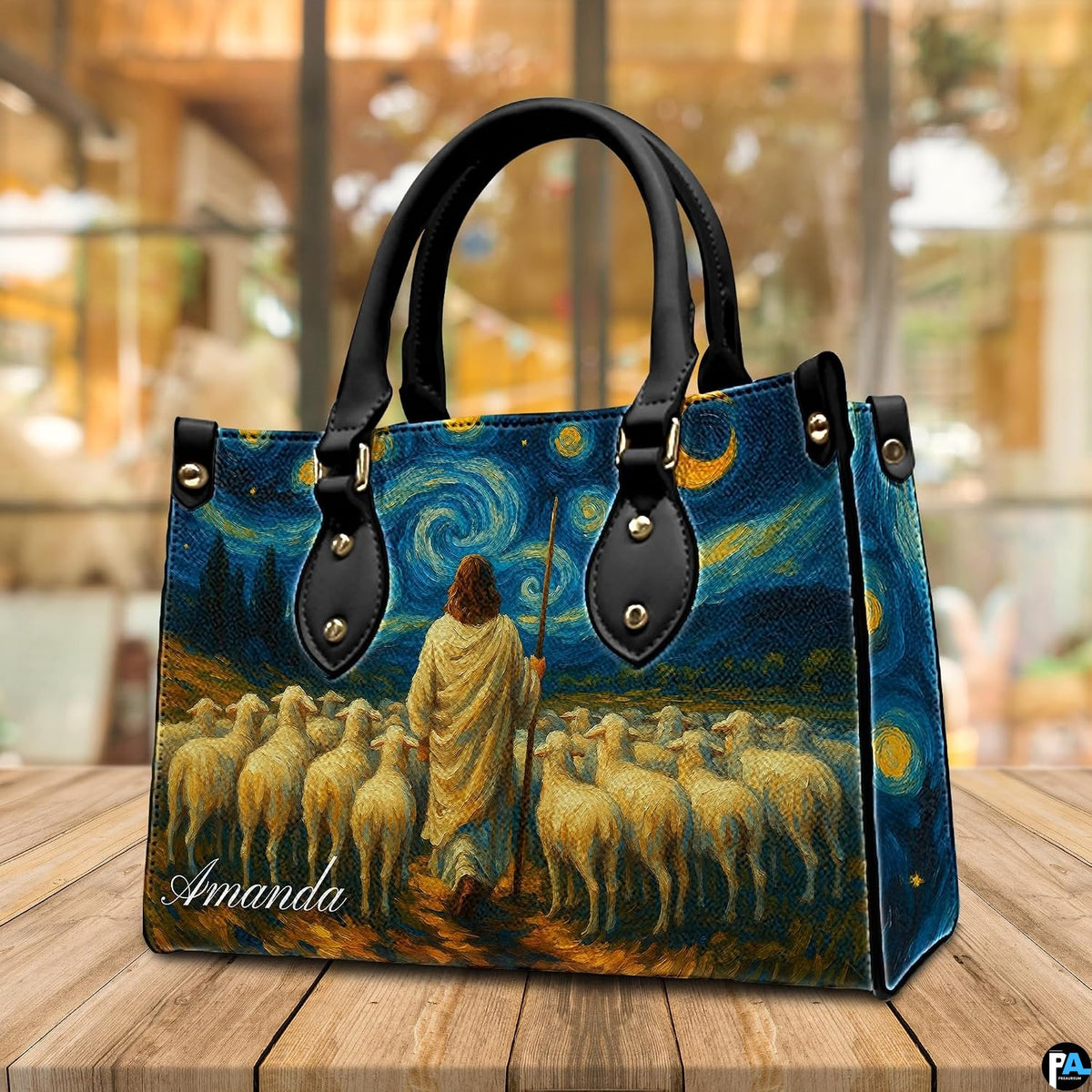 Close-up front view of handbag showing shepherd, grazing sheep, and swirling stars