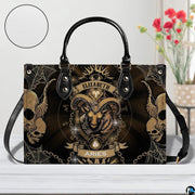 Gothic Ram Zodiac Handbag resting on a white table beside floral arrangement with texture inset.