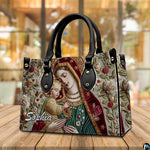Tapestry style Virgin Mary and Child handbag presented on a natural wooden tabletop