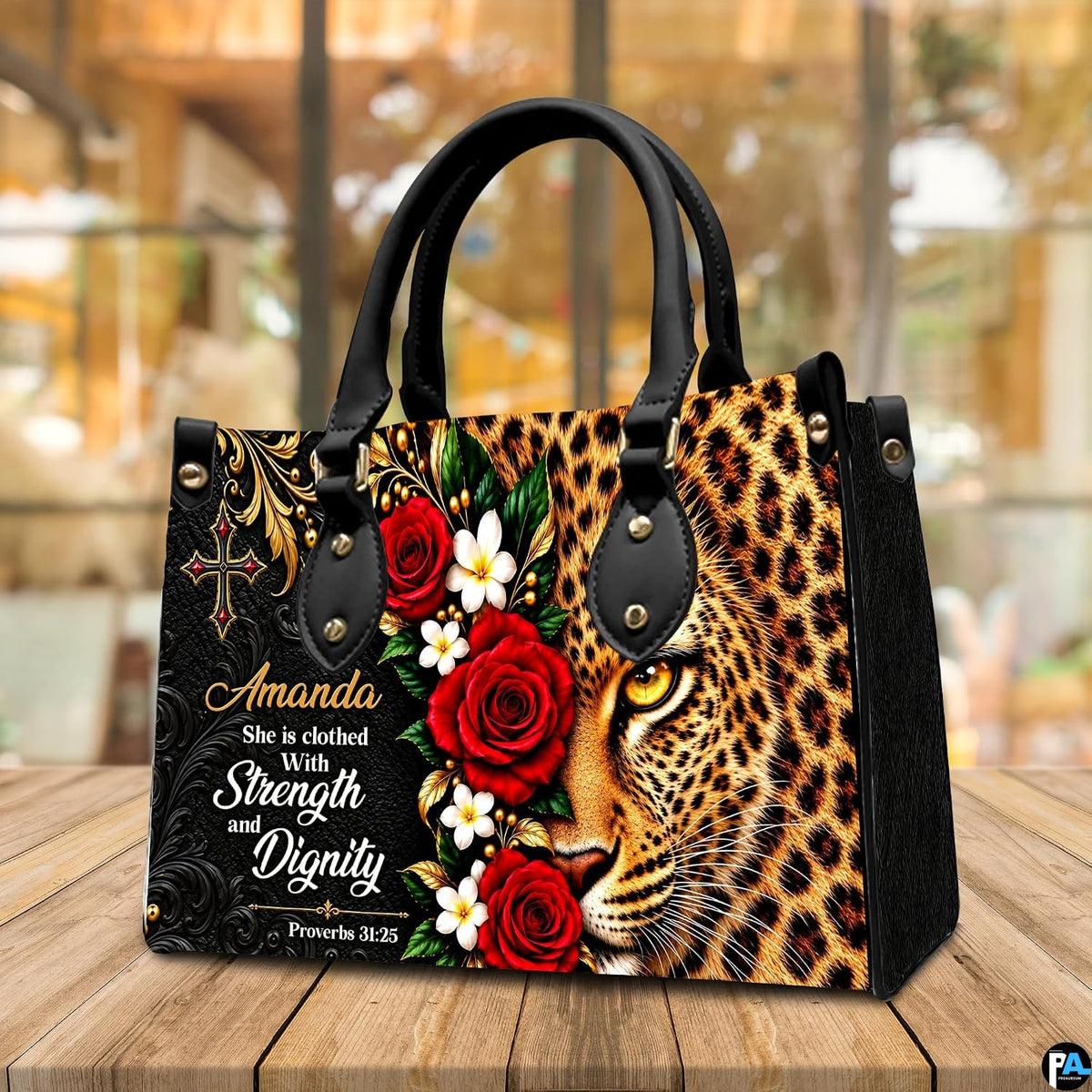 Leopard handbag displayed on wooden tabletop in front of sunlit cafe window.