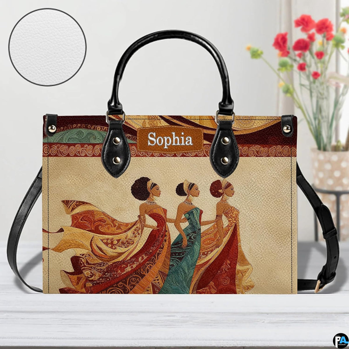 Tabletop perspective of the African queen handbag displayed with decorative blooms and texture swatch.
