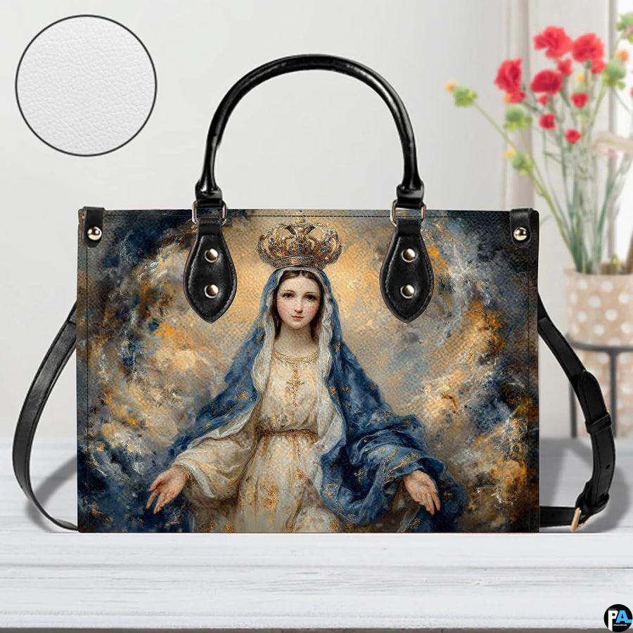 Queen of Heaven Marian handbag displayed on wooden tabletop with texture swatch and flowers