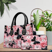 Tabletop display of black butterfly and pink daisy handbag set