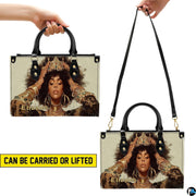 Top-handle and shoulder views of cream and gold crowned portrait handbag