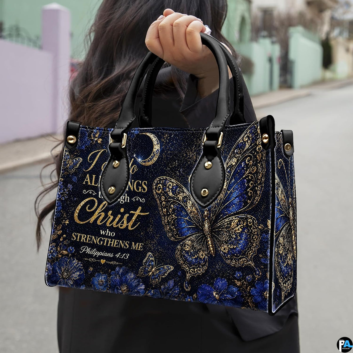 Outdoor lifestyle view showing royal blue butterfly artwork held by pedestrian along sidewalk.