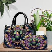 Handbag and matching wallet set displayed together on wooden table beside a green houseplant.