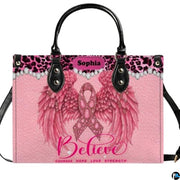 Pink angel wings art accessory displaying jeweled ribbon, feathered wings, and leopard trim on pink paneling.