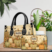 Pair showcase featuring smiling pumpkin artwork placed on wooden tabletop beside leafy potted plant.