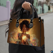Handbag carried by person outdoors demonstrating top handle style