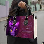 Outdoor presentation demonstrating the purple devotional cross handbag carried by a model.