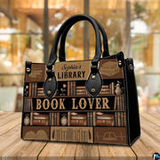 Three-quarter perspective view of vintage library handbag on a rustic wooden table.
