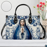 Praying Virgin Mary handbag beside floral vase with circular texture detail.