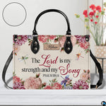 Scripture floral dragonfly handbag displayed on white table beside floral bouquet.