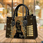 Silhouette faith handbag displayed on a tabletop in a bright interior environment.