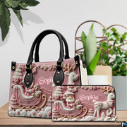 Display showing both pink Santa sleigh handbag and matching wallet on wood table.