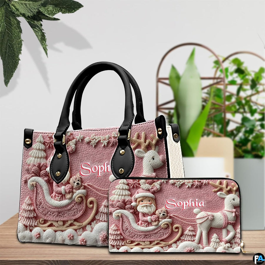 Display showing both pink Santa sleigh handbag and matching wallet on wood table.