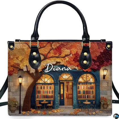 Front view of Autumn Bookstore Facade Handbag showing stone bookshop and colorful autumn canopy