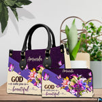 Floral butterfly handbag and wallet displayed on wooden table beside potted plant.