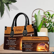 Empty tomb handbag and matching wallet set staged on table with green potted plants