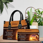 Empty tomb handbag and matching wallet set staged on table with green potted plants