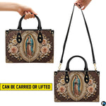 Handbag with Our Lady of Guadalupe artwork presented on natural wooden table