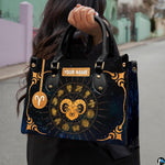 Side profile view of structured golden celestial zodiac ram handbag.