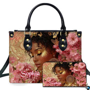 Front view showing golden glow afro portrait accessory paired with matching companion item amid pink blossoms.
