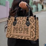 Model showcasing tan leopard print design outdoors along a sunlit pathway.