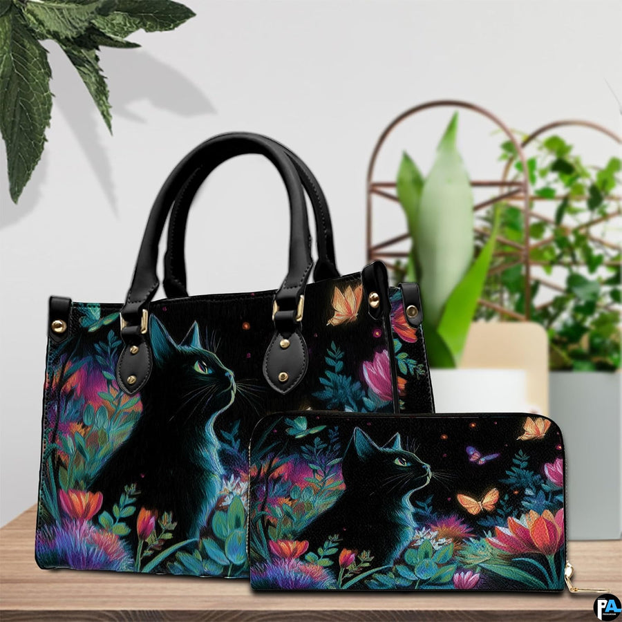 Tabletop presentation showing black cat flowers art on wood beside green houseplants.