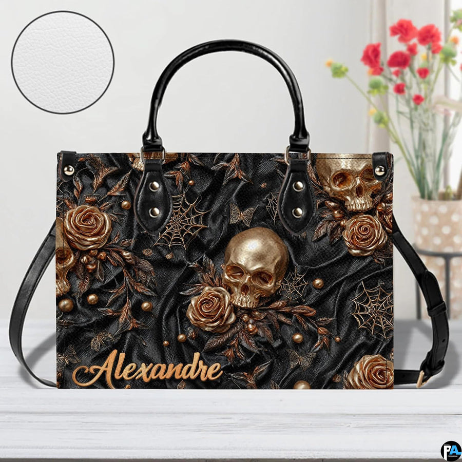 Golden skull handbag on white wooden table beside floral vase with texture swatch inset.