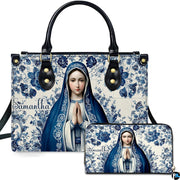 Front view of handbag and wallet set with praying Virgin Mary on blue floral ceramic tile background.