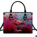 Street perspective of the colorful splatter flamingo shoulder bag.