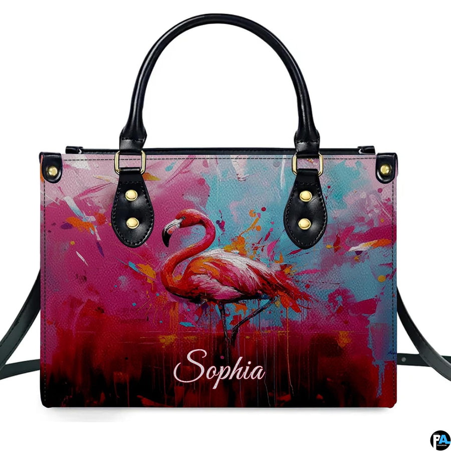 Street perspective of the colorful splatter flamingo shoulder bag.