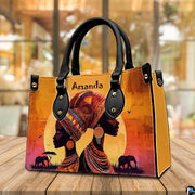 African sunset artwork presented resting on a wooden cafe tabletop against a blurred indoor setting.